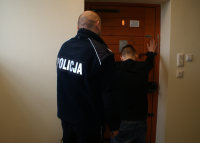 Policjant z zatrzymanym w pomieszczeniu dla osób zatrzymanych