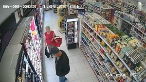 mężczyzna ogląda towar a kobieta zbliża sie do niego trzymając w ręku koszyk na zakupy.