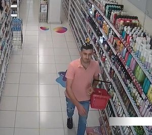 mężczyzna idący po sklepie w ręku trzyma koszyk na zakupy.