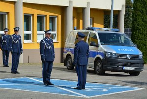 na zdjęciu widzimy dowódcę uroczystości składa meldunek I Zastępcy Komendanta Wojewódzkiego Policji w Łodzi inspektorowi Jarosławowi Rybce, w tle radiowóz i budynek komendy.