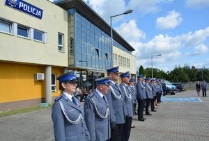 widzimy policjantów stojących w szyku na tle Komendy Powiatowej policji w Wieruszowie.