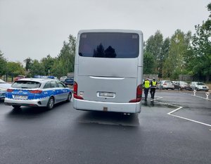 widzimy autobus i stojący obok niego radiowóz oraz policjantów.