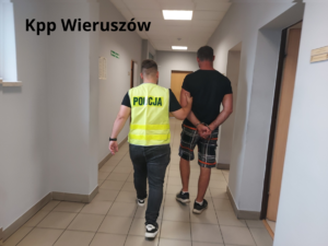 widzimy jak policjant prowadzi zatrzymanego i napis KPP Wieruszów.