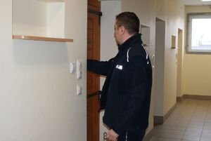 Umundurowany policjant zamyka "cele"w PDOZ.