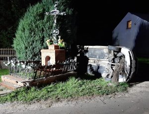 Widok uszkodzonej kapliczki i pojazdu.