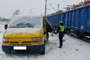 policjantka przy uszkodzonym busie w tle skład pociągu Cargo.