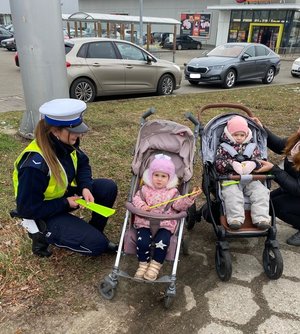 policjantka wręcza dzieciom odblaski.