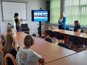 policjantka omawia sprzęt, który jest na wyposażeniu policjantów ruchu drogowego.