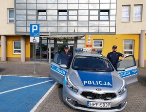 Dzielnicowi przed Komendą Powiatową policji w Wieruszowie stojący przy radiowozie.