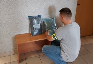 policjant zabezpiecza dwa worki z narkotykami.