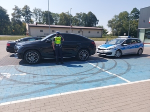 policjantka sprawdza czy podczasupału w samochodzie nie ma pozostawionych osób lub zwierząt.