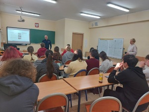 policjant podczas prelekcji z uczniami i nauczycielem.