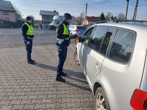 policjanci przy kontrolowanym samochodzie.