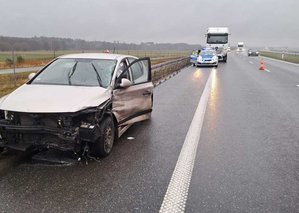 policjanci w trakcie zdarzenia drogowego, widzimy uszkodzony samochód osobowy i ciężarowy.