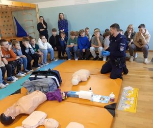 widzimy policjanta prowadzącego szkolenie z zakresu resuscytacji krążeniowo-oddechowej.