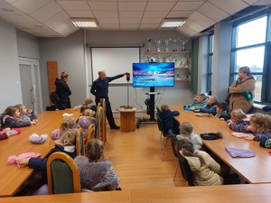 widzimy policjanta i przedszkolaków w auli podczas zajęć.