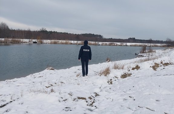 widzimy policjant stojącego na brzegu zbiornika wodnego.