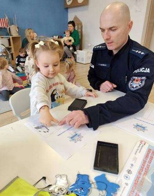 policjant pobiera odciski palców dziecku.