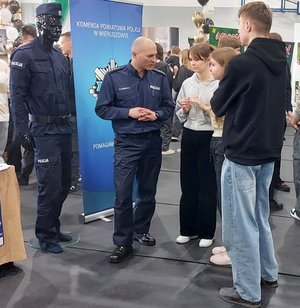 widzimy policjanta prowadzącego rozmowe młodzieżą.