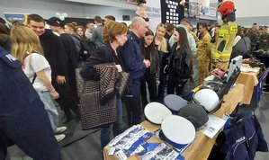 widzimy policjantów przy stoisku promocyjnym wraz z uczestnikami.