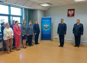 widzimy policjantów oraz pracowników komendy w pomieszczeniu.