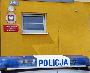 widzimy belkę radiowozu na tle komendy.
