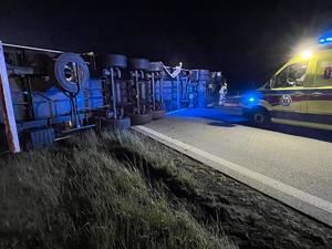 widzimy przewrócona ciężarówkę i pojazd pogotowia ratunkowego.