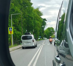 widzimy w odbiciu lusterka motocyklistę i jadącego busa.