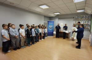 widzimy uczestników konkursu wraz z opiekunami oraz policjantami w pomieszczeniu