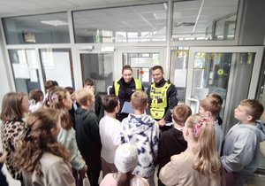 widzimy policjantów ruchu drogowego rozmawiających z uczniami.
