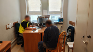 widzimy policjanta przesłuchującego mężczyznę.