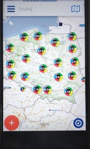 widzimy telefon komórkowy na którym widać mapę Polski z naniesionymi punktami w kolorze czerwonym.