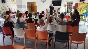 widzimy policjanta podczas prelekcji z uczniami.