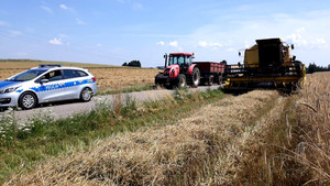 na zdjęciu widnieje radiowóz ciągnik rolniczy i kombajn zbożowy