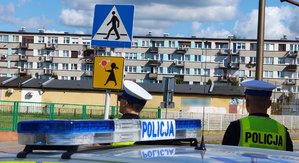 widzimy policjantów w rejonie oznakowanego przejścia dla pieszych.