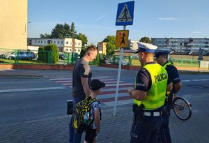 widzimy policjantów rozmawiających z opiekunem i dziećmi.