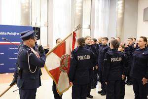 widzimy poczet flagowy oraz ślubujących policjantów w auli komendy.