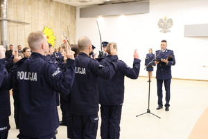widzimy Zastępce Komendanta Wojewódzkiego Policji w Łodzi inspektora Adama Jurka, ślubujących policjantów, a w tle Zastępce  Komendanta Wojewódzkiego Policji w Łodzi inspektor Anita Tim – Warchał.