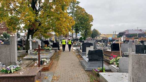 na zdjęciu widać policjantów patrolujących cmentarz