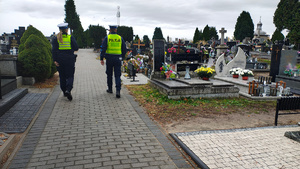widzimy policjantów patrolujących cmentarz.