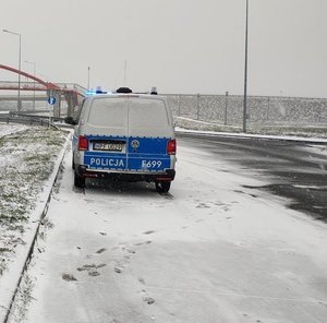 widzimy policyjnego busa, stojącego na jezdni pokrytej śniegiem.