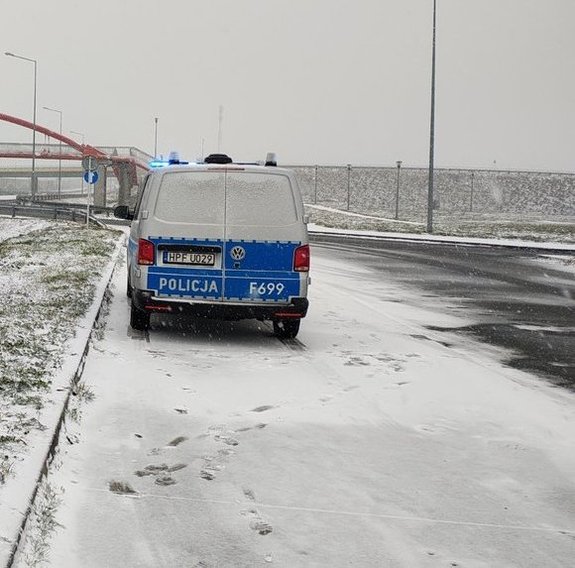 widzimy policyjnego busa, stojącego na jezdni pokrytej śniegiem.