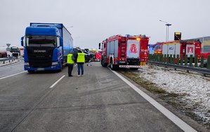 widzimy pojazdy biorące udział w wypadku i miejsce zdarzenia wraz z policjantami pracującymi na miejscu.