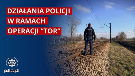widzimy policjanta stojącego przy przejazdach kolejowych.