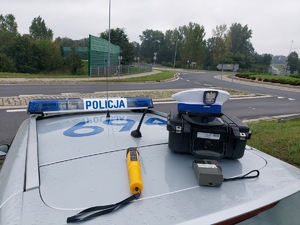 widzimy na dachu policyjnego radiowozu czapkę policyjna, urządzenie do badania stanu trzeźwości.