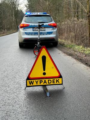 widzimy policyjny radiowóz na drodze i znak uwaga wypadek.