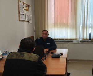 widzimy policjanta, który przebywa w pokoju z zatrzymanym.
