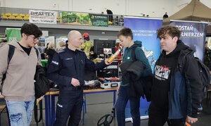 widzimy policjantów rozmawiających z młodzieżą, widać policyjne stoisko promocyjne.
