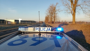 widzimy policyjny pojazd jadący drogą.