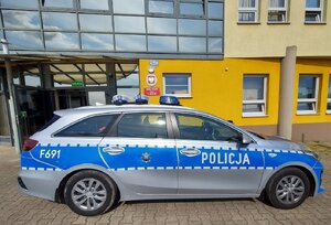 widzimy policyjny radiowóz na tle komendy.